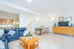 a living room with a blue couch and a table at Jouvacations Villa 3 Freser con piscina compartida in Empuriabrava