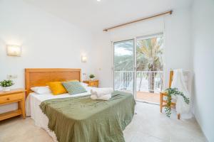 a bedroom with a bed and a large window at Jouvacations Villa 3 Freser con piscina compartida in Empuriabrava +40 photos