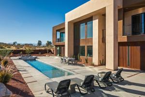 a house with a swimming pool and chairs around it at Suncrest by Fieldtrip - JT Modern w Pool and Views in Joshua Tree
