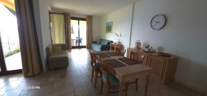 a living room with a table and chairs and a clock at Lakeview Residence in Oggebbio