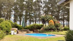 a swimming pool in a yard with a bench and trees at Gillys Accommodation in Camperdown
