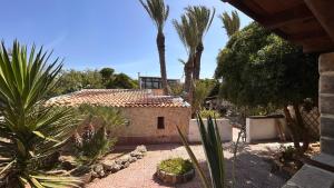 a house with a courtyard with palm trees and a building at Il Villaggetto sul Mare in Favignana