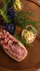 a table with a plate of meat and some vegetables at Hotel Lucija in Most na Soči