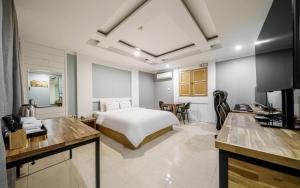 a hotel room with a bed and a kitchen with a kitchen at Cats Hotel in Puch'ŏn-yŏk