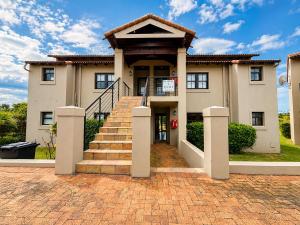 a house with a staircase in front of it at Captains Quarters in Plettenberg Bay
