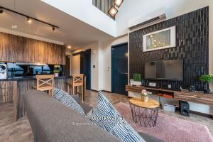 a living room with a couch and a tv at Expressionz Suites, 300mbps Wifi, near KLCC, IJN by Wodages in Kuala Lumpur