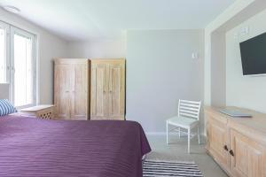 a bedroom with a purple bed and a tv at Villa Tuuliniemi in Muurame