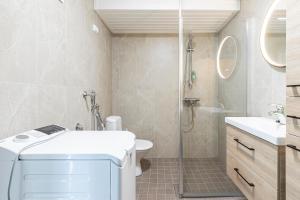 a bathroom with a shower and a toilet and a sink at Villa Tuuliniemi in Muurame +35 photos