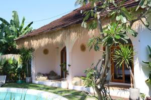 a small house with a thatched roof at La Calma Villa in Gili Islands