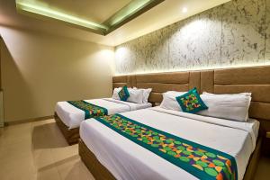 two beds in a hotel room withskirts at Treebo Amber International Mumbai Airport T2 in Mumbai +40 photos