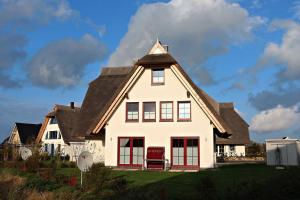 a white house with a gambrel roof at Seestern in Dranske