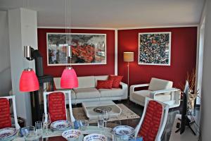 a living room with red walls and a table and chairs at Seestern in Dranske