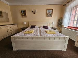 a bedroom with a large white bed with two pillows at Mini Apart Hotel Abraka in Český Krumlov