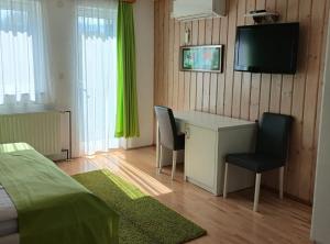 a bedroom with a desk and a television on a wall at Villa Lika in Plitvička Jezera