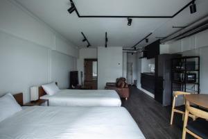 a room with two beds and a desk and a table at NIYS apartments 37type in Tokyo