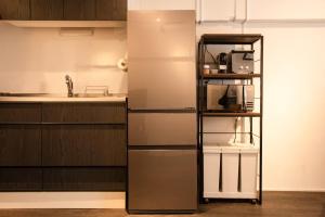 a kitchen with a refrigerator freezer next to a counter at NIYS apartments 37type in Tokyo