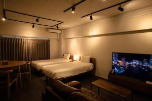 a hotel room with two beds and a flat screen tv at NIYS apartments 37type in Tokyo