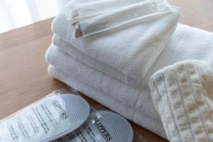 a pile of towels and a thermometer on a table at NIYS apartments 37type in Tokyo +42 photos
