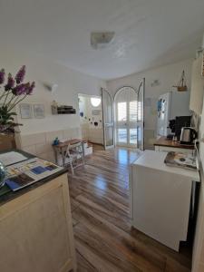 a kitchen and living room with a counter and a table at B&B Mare di Ricordi Camera in San Foca