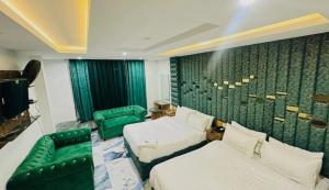 a hotel room with two beds and a couch at Hotel One Ten Mall Road Murree in Murree