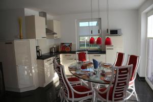 a kitchen with a table and chairs in a kitchen at Seestern in Dranske +15 photos