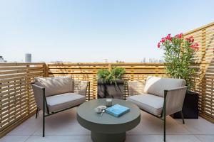 a patio with two chairs and a table on a balcony at Appart Hôtel Résidence Courcelle in Levallois-Perret