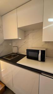 a black microwave on a white kitchen counter at Son Veri LUXURy HOME in Cala Blava