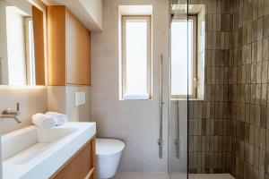 a bathroom with a shower and a toilet and a sink at Appart Hôtel Résidence Courcelle in Levallois-Perret