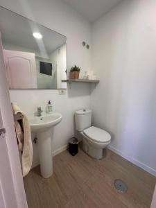 a bathroom with a toilet and a sink and a mirror at Puerto Nest Hostel in Puerto de la Cruz