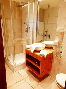 a bathroom with two sinks and a shower at Berghotel Arthurhaus in Mühlbach am Hochkönig +38 photos