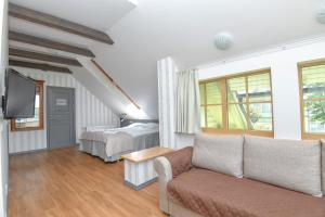 a living room with a couch and a bed at Kurgo Villa hotel in Pärnu