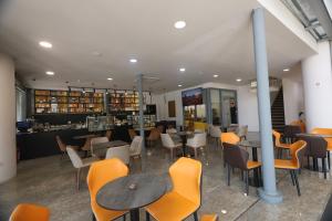 a restaurant with tables and chairs and a counter at Metro Hotel Terminal in Tirana