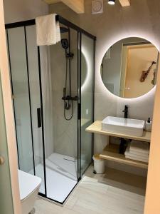 a bathroom with a shower and a sink and a mirror at Sol Chalet Maramures in Borşa +39 photos
