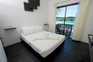 a bedroom with a bed with a view of the ocean at Aman Dan Laut in Perhentian Islands +36 photos