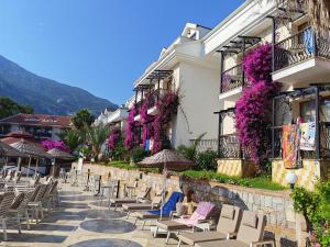 a row of chairs and umbrellas on a patio at Telmessos Neva Hotel - Halal-Non Alcoholic All Inclusive-Muhafazakar Hotel in Oludeniz