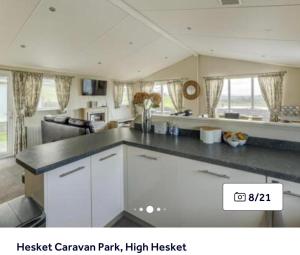 a kitchen with white cabinets and a counter top at 36 Ravens Nest large 3 bedroom lodge with views No sign written vans allowed on site in High Hesket