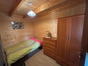 a small bedroom with a bed and a dresser at Agroturystyka i Domki Zacisze in Jarosławiec