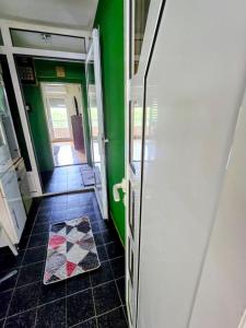 a hallway with green walls and a tile floor at MiR in Londža +1 photo