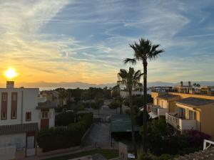 a sunset over a city with palm trees and buildings at Son Veri LUXURy HOME in Cala Blava