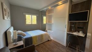 a bedroom with a bed and a desk and a television at Son Veri LUXURy HOME in Cala Blava