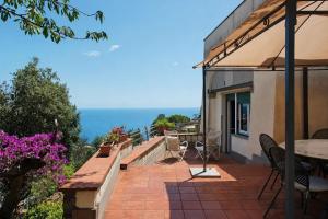 a patio with a table and chairs and the ocean at Villa Roberta Pool, wifi & Parking in Arenzano