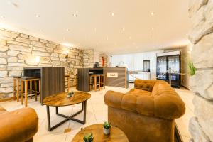 a living room with a couch and a stone wall at Hotel Bürger in Siegen