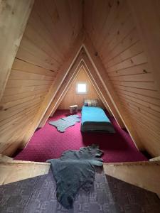 an attic room with a bed in a wooden tent at Mirno mjesto in Mujakovići