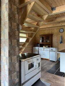 a kitchen with white appliances and a wooden ceiling at Mirno mjesto in Mujakovići