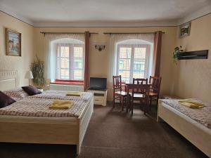 a bedroom with two beds and a table and chairs at Mini Apart Hotel Abraka in Český Krumlov