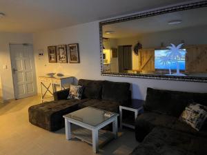 a living room with a couch and a table and a mirror at Laguna La Crete 33 in Uvongo Beach