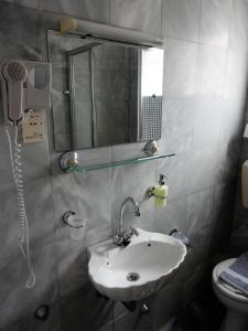 a bathroom with a sink and a mirror and a toilet at Grivas Apartments in Syvota