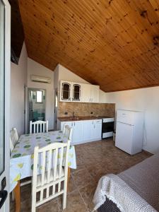 a kitchen and dining room with a table and chairs at Villa DEA in Velipojë