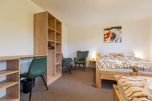 a bedroom with a bed and a desk and chairs at Penzion Kopaninky in Bítov