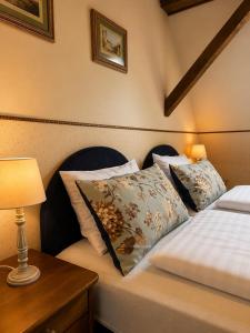 a bedroom with two beds and a table with a lamp at Kastélykert Vendégház in Bózsva +10 photos